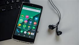  cellphone and earbuds next to a computer